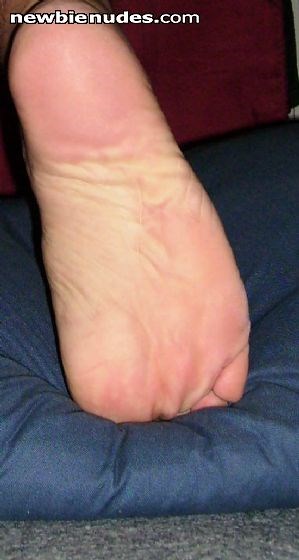 Wife steps over pillows while she leaves the living-room