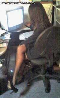 My wife at a computer playing with her high heels. Lovely legs, don't you t...