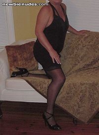 Wife in black minidress, gartered hose & heels at a bed & breakfast on an a...