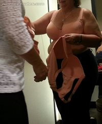 Dressing room door open teying on bras